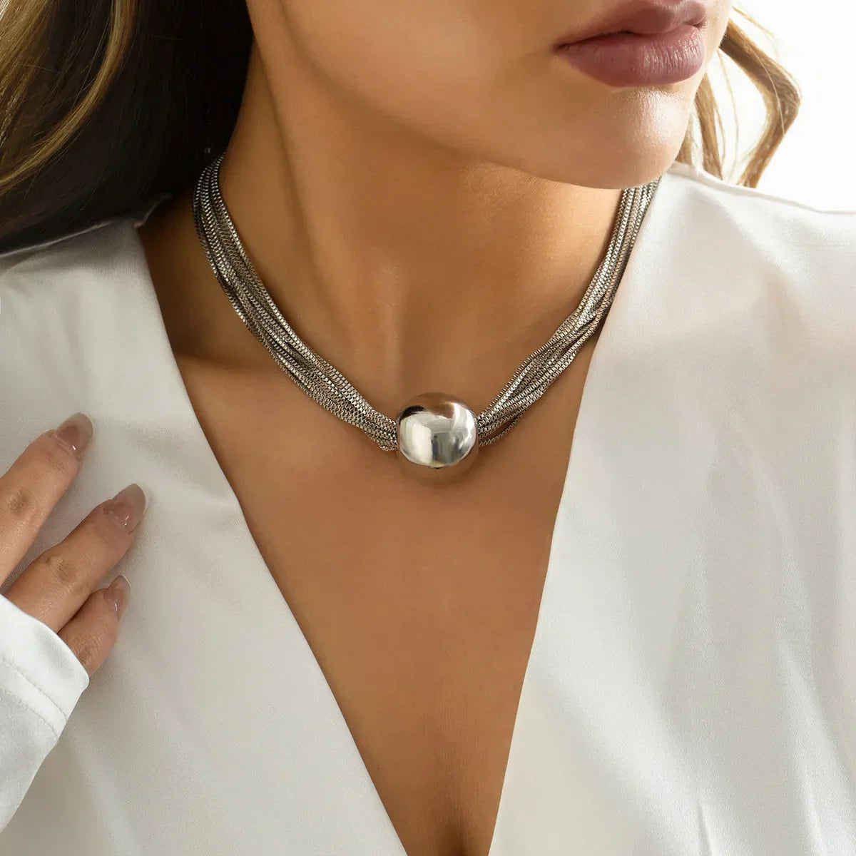 Elegancki wielorzędowy naszyjnik z błyszczącą metalową kulą jako zawieszką