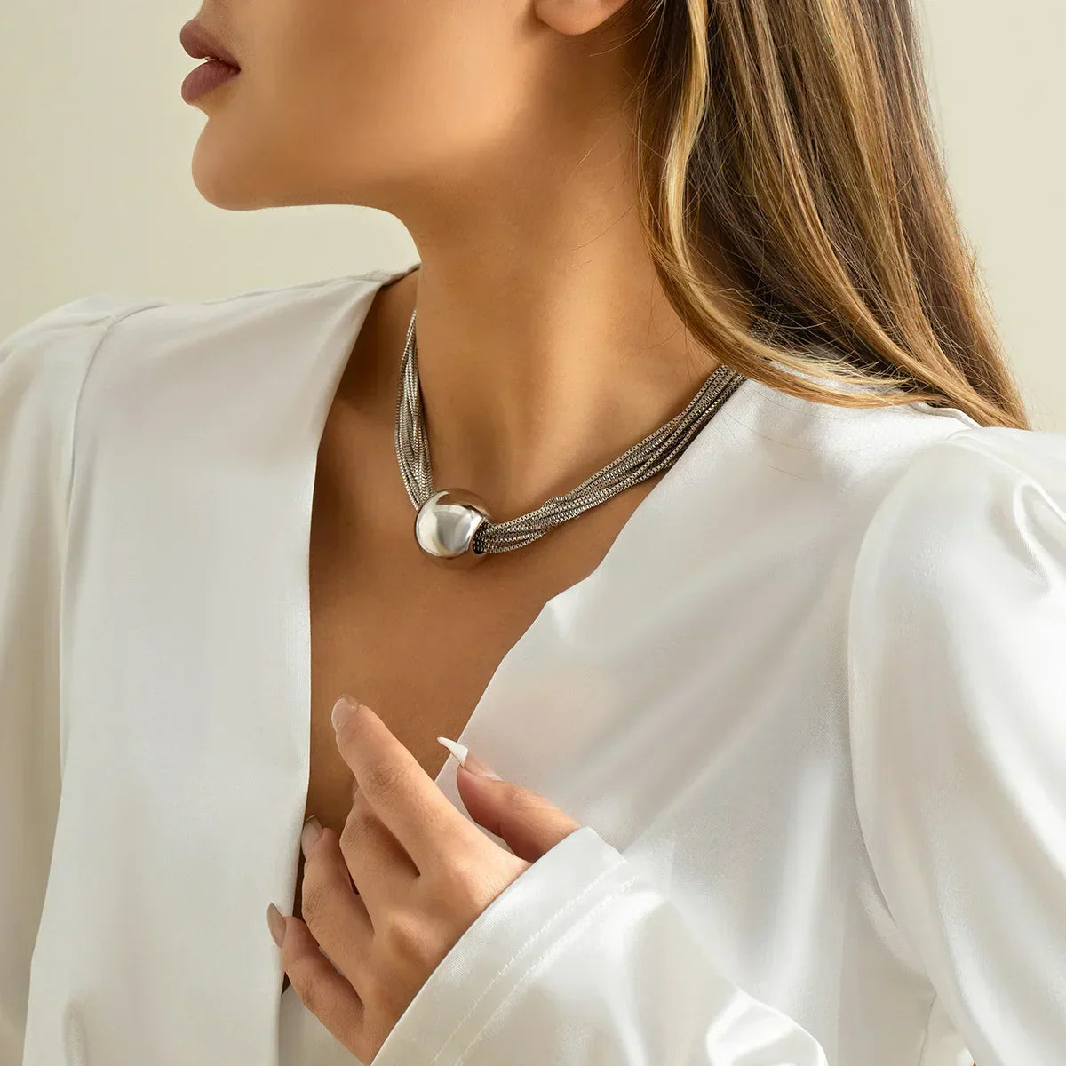 Elegancki wielorzędowy naszyjnik z błyszczącą metalową kulą jako zawieszką
