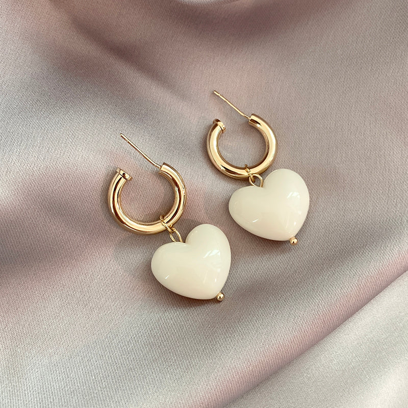 Szykowne kolczyki koła z lśniąco białymi zawieszkami w kształcie serca